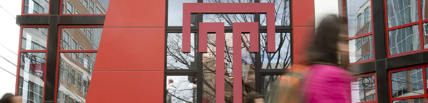 Students walking past the Temple T on the exterior of the Student Center